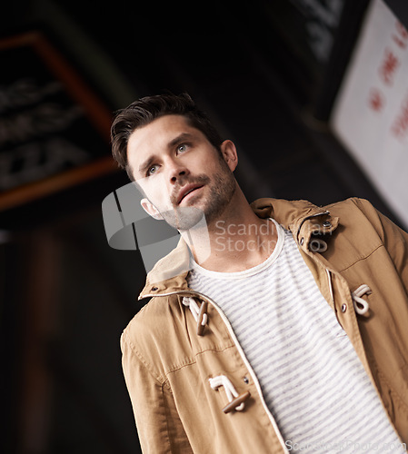 Image of Man, face and serious in town with fashion on low angle with urban style, trendy outfit and confidence. Male person, walking and outdoor view in town with wellness, casual clothes and morning travel