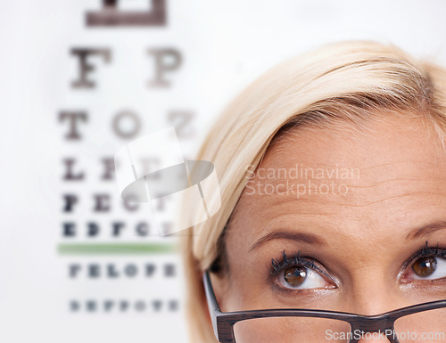 Image of Woman, glasses and reading of chart for eye test, wellness and frame in closeup. Person or ophthalmologist .looking up, thinking and ideas for optometry, vision and lens check or exam and assessment