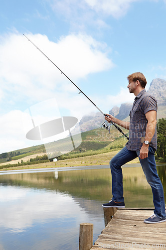 Image of Fishing, pole and man in nature for travel, break or stress relief at a lake on vacation, holiday or trip. Fish, line and calm male person at outdoor river for water, adventure or peace in a forest