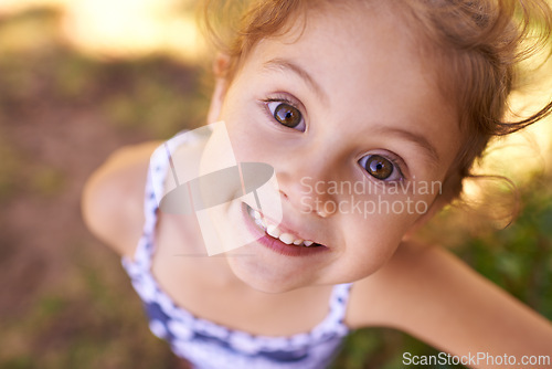 Image of Girl, child and portrait in park with top view, play games outdoor in nature for childhood and fun with fresh air. Happiness, travel and freedom with youth, public garden or playground with closeup