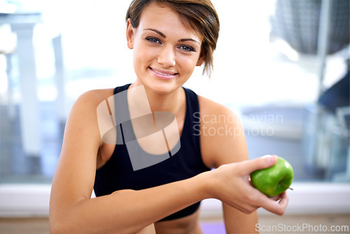 Image of Portrait, fitness and happy woman with apple in gym for diet, nutrition and wellness with healthy body. Face, exercise and person eating fruit for organic food, vitamin c or benefits after sport