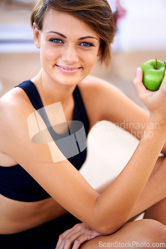 Image of Portrait, fitness and happy woman with apple in gym for diet, nutrition or wellness with healthy body. Face, smile and person with green fruit and eating organic food with vitamin c for benefits