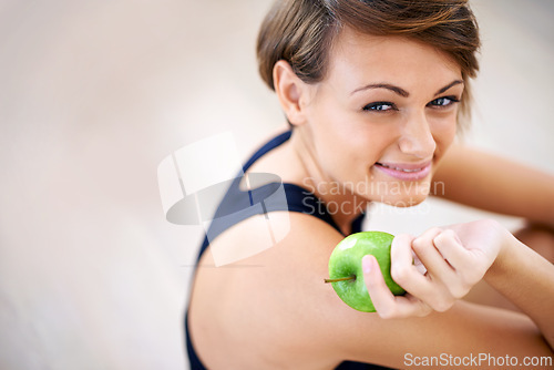 Image of Portrait, exercise and happy woman with apple in gym for diet, nutrition or wellness with healthy body. Face, fitness and person eating fruit for vitamin c or benefits of organic food on mockup space