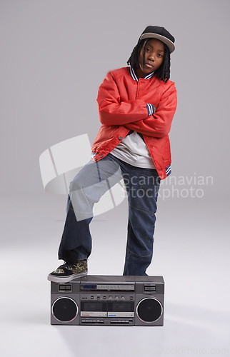 Image of Child, hip hop and cool portrait with radio for music and rap in a studio with urban clothing. Fashion, African kid and boombox with trendy clothes and youth swag with confidence and grey background