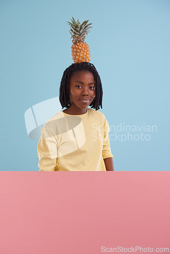 Image of Portrait, banner or boy child with pineapple in studio for health, wellness or gut health on blue background, Fruit, balance or face of African teen model with organic diet poster, nutrition or detox