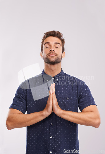 Image of Young man, studio and hands together in prayer, trust and hope in religion by grey background. Entrepreneur, gratitude or asking god for direction or blessing, guidance or worship in christian faith