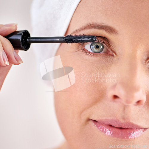 Image of Makeup, mascara or portrait of woman with brush in studio for beauty, cosmetics or application. Eyelash, white background or face of mature model with product or tool for volume, glamour or aesthetic