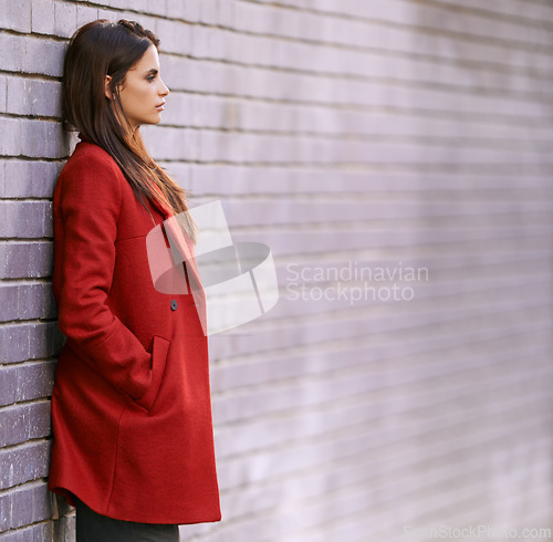 Image of Winter, jacket and woman on wall with fashion in city for travel with cool style in red coat. Streetwear, clothes and girl outdoor on building background with confidence and pride in New York spring