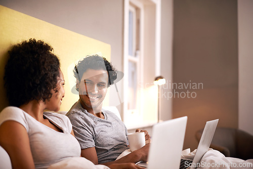 Image of Apartment, laptop and couple with smile for working from home in bedroom, eye contact and together with love. Partners, woman and man on bed of house with technology for career and coffee in morning