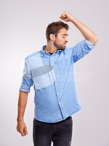 Image of Man, smelling armpit and sweat stain, bad hygiene or body odor with stink isolated on white background. Hyperhidrosis, poor hygiene and dirty, foul or negative with disgust for underarm in studio