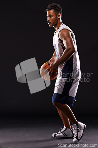 Image of Man, basketball player and playing game in studio as athlete for workout competition, training or black background. Male person, sports and exercise champion or professional, fitness or mockup space