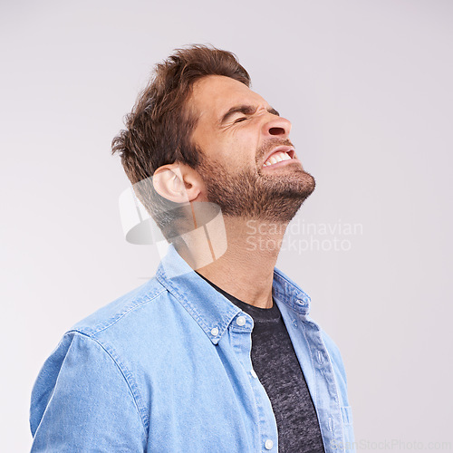 Image of Burnout, angry and frustrated with man, stress and facial expression on a grey studio background. Body language, person and model with emotions and furious with anxiety and anger with aggressive