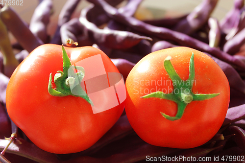 Image of red tomatoes and lilac pods of haricot