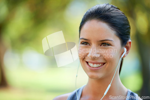 Image of Woman, earphones and music for fitness in park, closeup and audio inspiration for training in marathon race. Young lady, happy or streaming radio for exercise, commitment or morning workout in nature