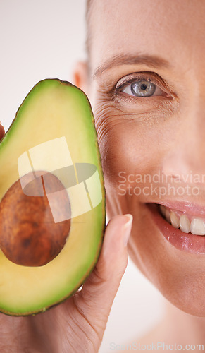 Image of Skincare, avocado and closeup portrait of woman in studio for health, wellness or natural face routine. Smile, beauty or mature person with organic fruit for dermatology treatment by white background