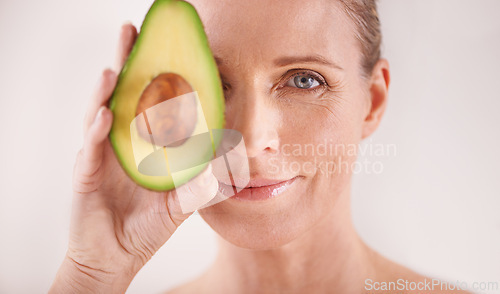 Image of Cosmetic, avocado and portrait of woman in studio for health, wellness or natural facial routine. Skincare, beauty and mature person with organic fruit for dermatology treatment by white background.