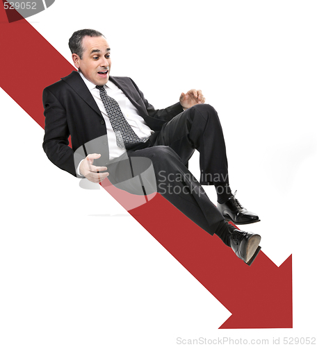 Image of Businessman sliding down red arrow