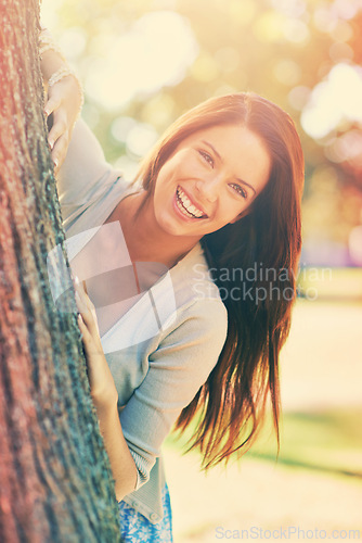 Image of Woman, park and tree with smile, portrait and happiness with joy and green fun for nature. Lady, laugh and sun with grass, forest and bokeh for exited playful summer with optimism and sunshine