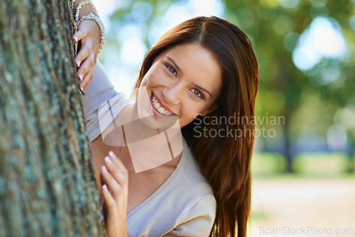 Image of Woman, enviroment and tree with smile, portrait and happiness with joy and green fun for nature. Lady, laugh and sun with grass, forest and bokeh for exited playful summer with optimism and sunshine