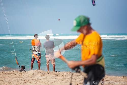 Image of Active sporty people enjoying kitesurfing holidays and activities on perfect sunny day on Cabarete tropical sandy beach in Dominican Republic.