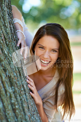 Image of Woman, lean and tree with smile, portrait and happiness with joy and green fun for nature. Lady, laugh and sun with grass, forest and bokeh for exited playful summer with optimism and sunshine