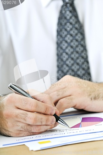Image of Office worker writing on reports