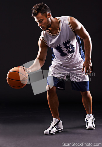 Image of Man, playing and basketball player in studio for sports athlete for workout competition, training or black background. Male person, bounce and exercise performance or professional, fitness or mockup