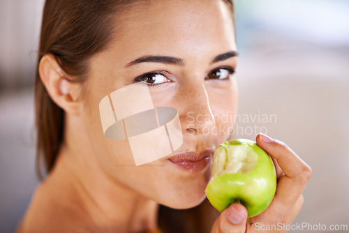 Image of Woman, portrait and apple for nutrition in home, organic fiber and fruit for wellness. Happy female person, vitamins and minerals for healthy living, eating snack and vegan food in closeup for diet