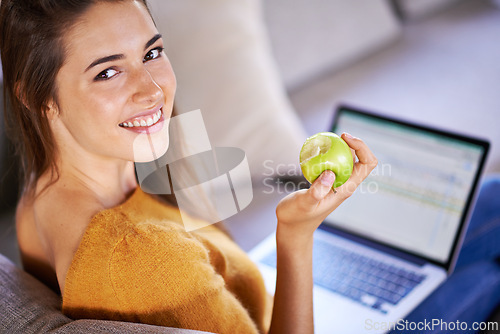 Image of Woman, portrait and apple by laptop on couch, internet and nutrition while studying online. Person, student and university website for e learning, home and organic fruit for diet or minerals on app