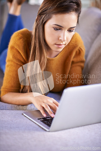 Image of Relax, home and woman with a laptop, typing and connection with internet in a living room. Person on couch, apartment and girl with a computer and research with website information, tech and network