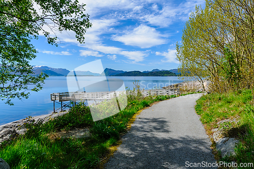 Image of Serene morning stroll along idyllic seaside path amidst majestic