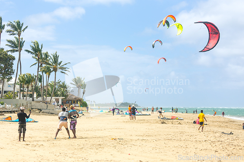 Image of Crowd of active sporty people enjoying kitesurfing holidays and activities on perfect sunny day on Cabarete tropical sandy beach in Dominican Republic.