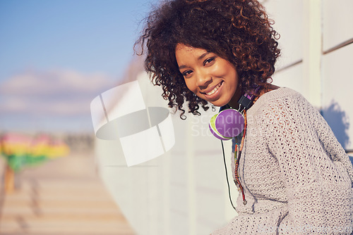 Image of Woman, smile and portrait in city for travel, walk and break in urban for summer, fun and outdoor. African person and happy with headphones for music, streetwear and journey in town for trip