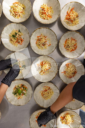 Image of Close-up of a chef's hands arranging food