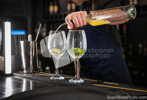 Image of Bartender pouring a mixed drink into two elegant glasses