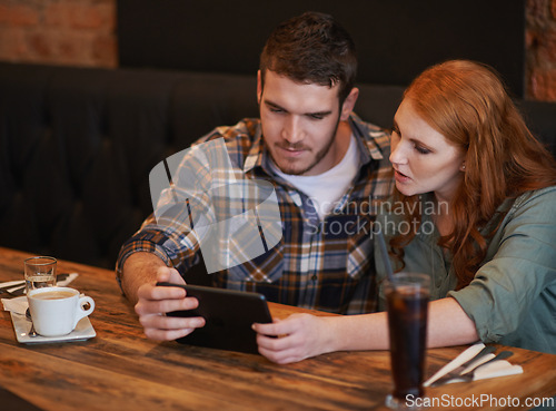 Image of Couple, browsing and checking menu with tablet for dinner date, streaming or review at indoor restaurant. Young man and woman chilling or relax with technology for social media at cafe or coffee shop