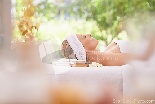 Image of Lady, spa and rest for zen, peace and wellness with relaxation and calm. Woman, towel and massage table at resort, lounge or luxury parlor with rose for holistic body and skincare for detox and break