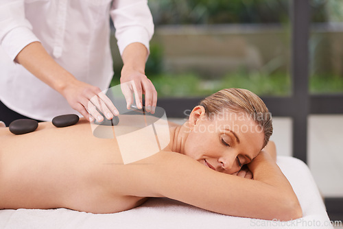 Image of Girl, spa and hands with hot stone for massage, wellness and relax in hotel. Physical therapy, holistic and female person in holiday or vacation in California for health, peace and back skin detox