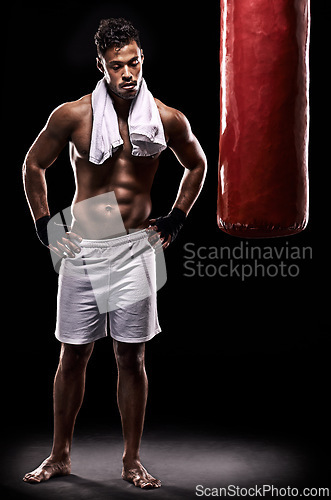 Image of Sport, boxer and man with towel in studio with gloves for training with strength and muscle. Adult, athlete and male person in dark background, healthy and power with body, punching bag and tired