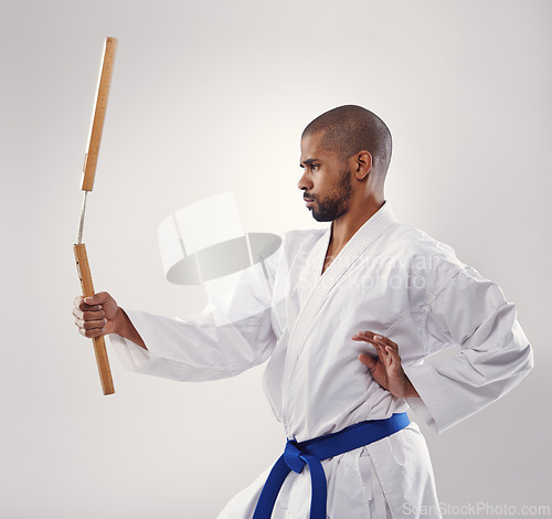 Image of Nunchaku, karate and man in martial arts fight with weapon in training for defence in white background of studio. Nunchucks, exercise and fighting with equipment in sport or gym with creative skill