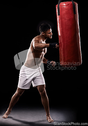 Image of Boxing, man and training in studio with punching bag for workout, exercise or competition fight with fitness. Athlete, boxer and confidence for martial arts with energy or topless on black background