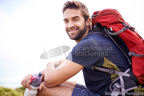 Image of Man, hike and smile for adventure with water bottle or backpacker for fitness, workout and activity on mountain top. Portrait, happy and outdoor in nature for healthy mind in woods or forest.