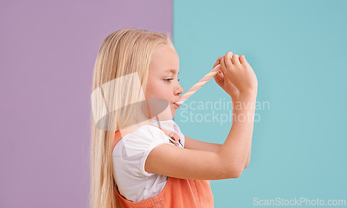 Image of Child, candy and eating dessert in studio for unhealthy snack or sugar meal, sweets or mockup space. Female person, food and split purple with blue background for party or lollipop, treat or hungry