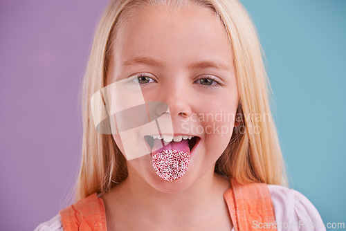 Image of Child, portrait and tongue out in studio for crazy, silly and playful facial expression with color block background. Happy, goofy and funny face of young girl for comic, humor and joking by sprinkles