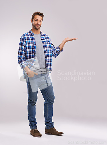 Image of Portrait, presentation and casual man in studio with smile, deal announcement and product placement. Showing, advice and creative person pointing at offer, notification and white background mockup