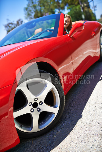 Image of Convertible, sports car and driving closeup with wheel in city, outdoor in summer and woman on road trip. Luxury, transport or driver to travel on highway with happiness in red vehicle on street