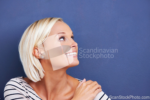 Image of Woman, studio and space for mockup, happiness and smile for confidence. Girl, thinking and vision for fashion, design and creative idea with style and positivity isolated on blue wall background