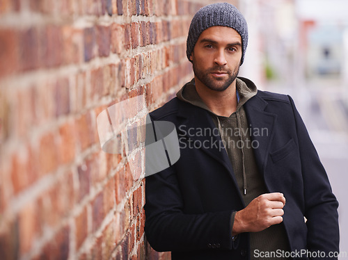 Image of Man, portrait and urban style by brick wall downtown for aesthetic, modern and vacation for city culture. Male person, trendy winter outfit for streetwear fashion for creative career in New York