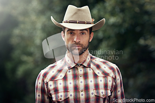 Image of Man, portrait and outdoor cowboy clothes, western culture and countryside ranch in Texas. Male person, hat and flannel fashion for farmer aesthetic, nature and plaid style by trees or outside bush