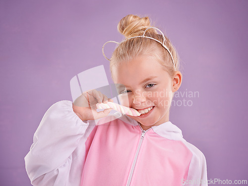 Image of Studio, portrait and child with candy, marshmallow and tasty dessert for snack in isolated pastel purple background. Sweets, happy childhood and face of young girl for yummy food, hungry and eating